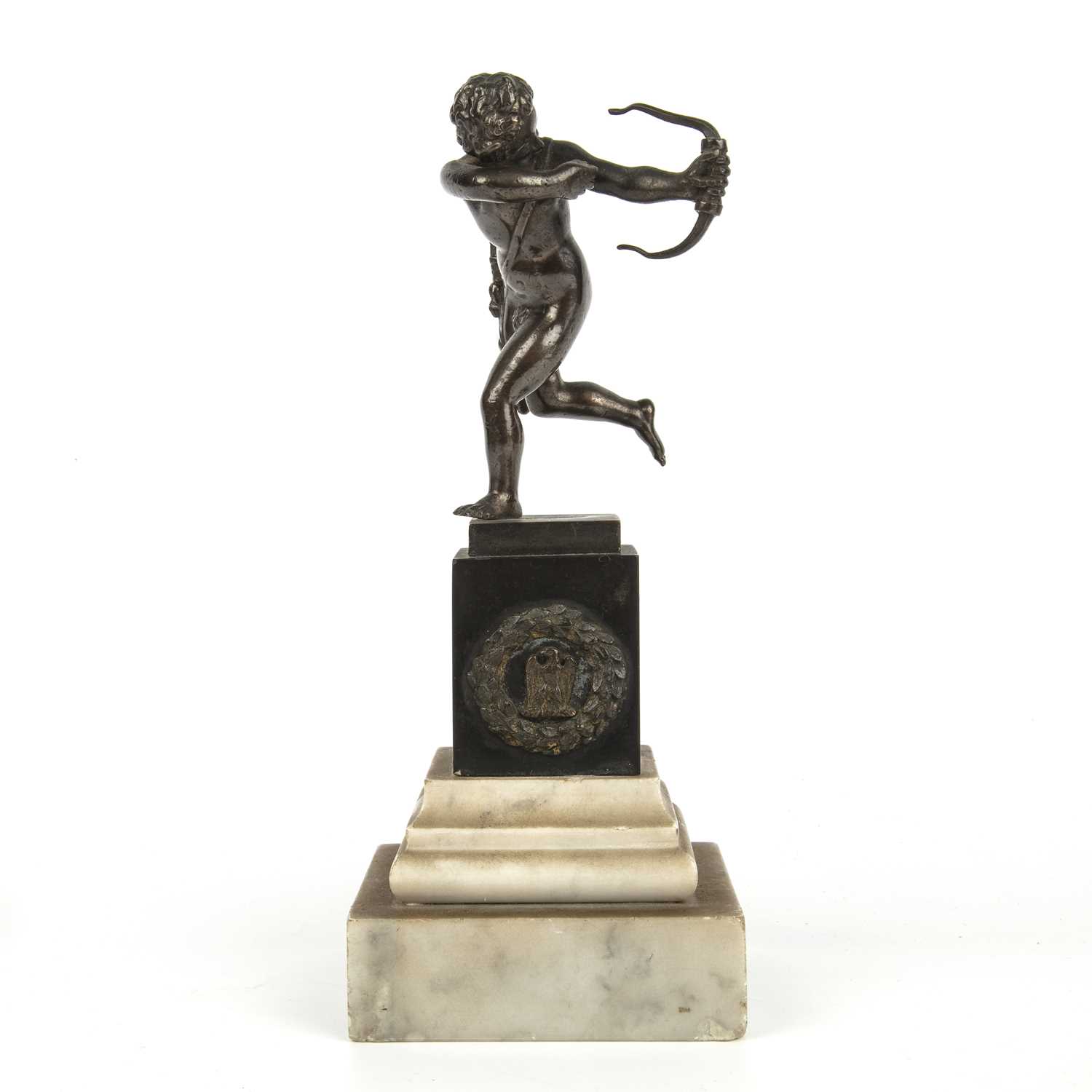A 17th or 18th century or later bronze depicting cupid on a slate and hardstone base, in the
