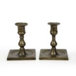 A pair of mid 18th century brass lantern candlesticks each with baluster stems and square bases,