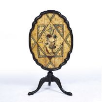 An early 19th century ebonised and painted tilt-top tripod table with a shaped top and turned