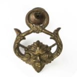 An 18th or 19th century gilt metal door knocker with a satire mask decoration, 15cm wide x 18cm