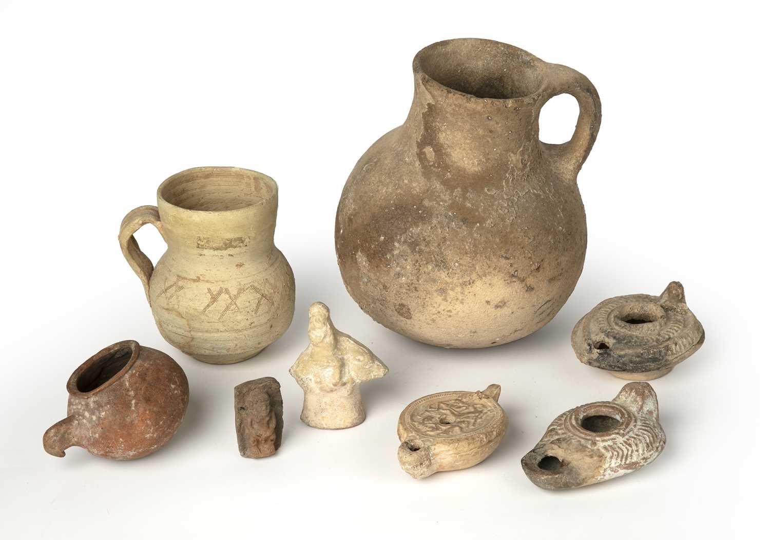 A group of ancient artefacts to include three Roman oil lamps, a figure riding a boar, a small