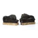 A pair of early 19th century Grand Tour bronze recumbent lions each mounted on white marble bases,