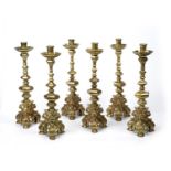 A set of six heavy gilt metal candlesticks with knopped stems and scrolling triform bases, each 13cm
