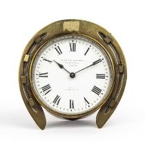 A late 19th century brass horseshoe desk top timepiece, the white enamel roman dial inscribed