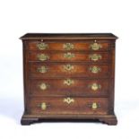 An 18th century oak chest of five long graduated drawers having a brushing slide, brass handles