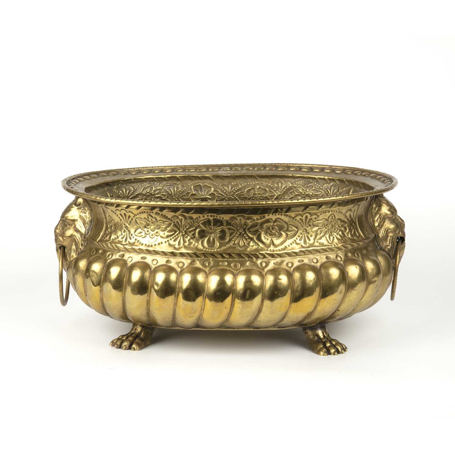 A 19th century sheet brass wine cooler with lion's mask handles and gadrooned decoration, raised