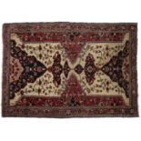 An early 20th century Middle Eastern red and blue ground rug with geometric foliate decoration.