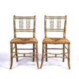 A pair of Regency style faux bamboo painted side chairs with rush seats, each 44cm wide x 39cm