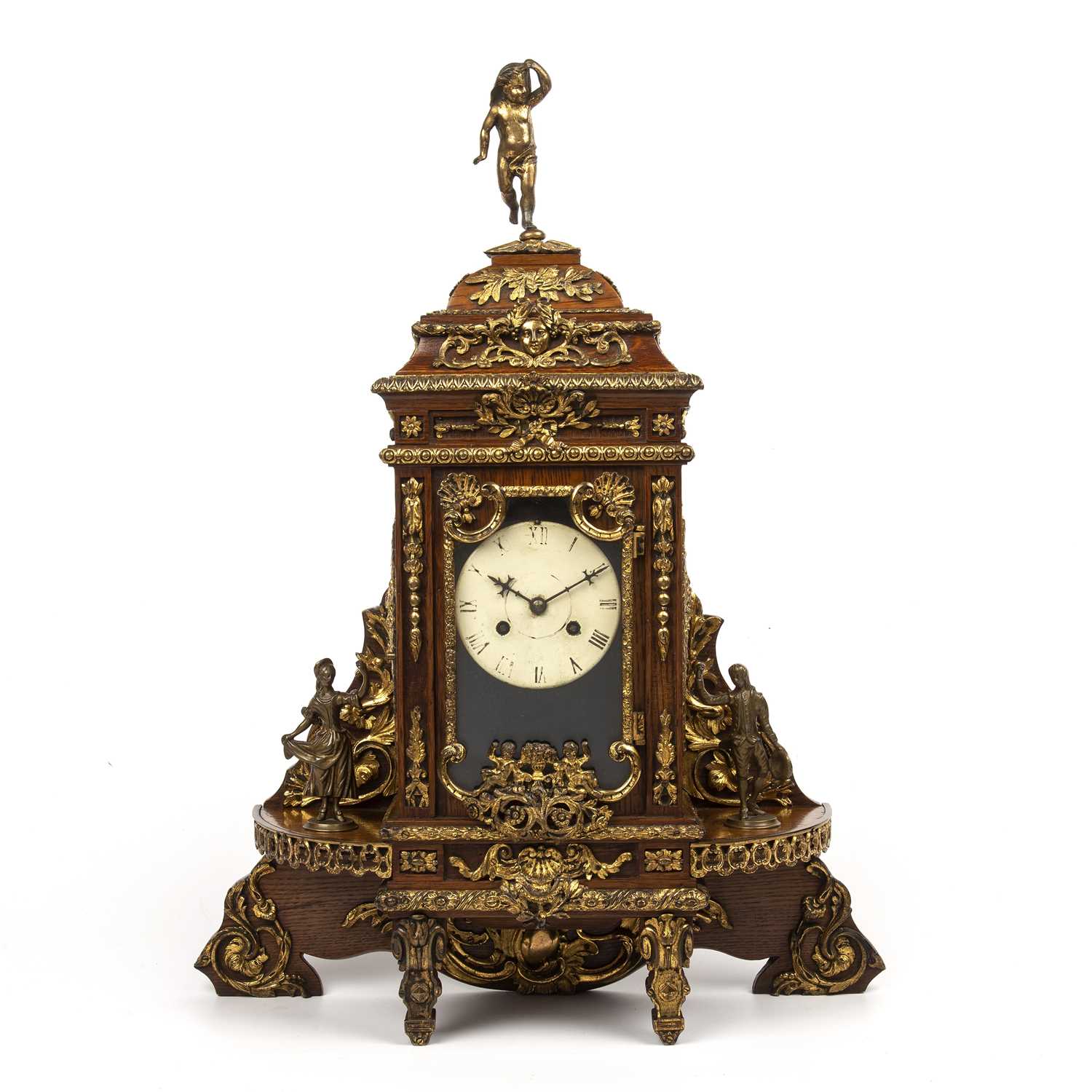 A late 19th century continental oak cased mantle clock with gilt metal figural decoration. 46cm wide