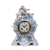 A 19th century French porcelain mantel clock encrusted with a cherub and flowers, having an