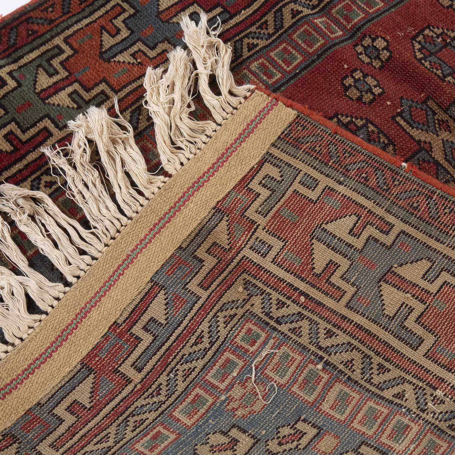 An early 20th century Middle Eastern red and blue ground rug with geometric foliate decoration. - Image 4 of 4