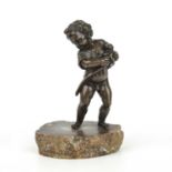 An 18th century bronze cherub with a small dog in its arms, mounted on a later agate slice,