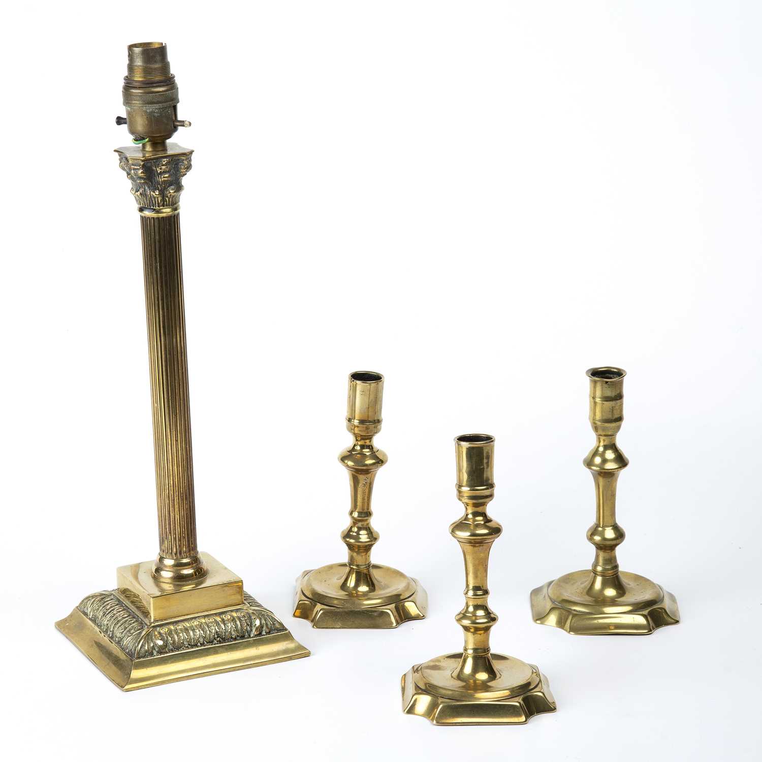 Three early 18th century English brass candlesticks the largest 17cm in height together with a