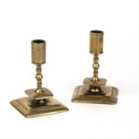 A pair early 18th century brass dwarf candlesticks with knopped stems and square bases, 8.5cm wide x