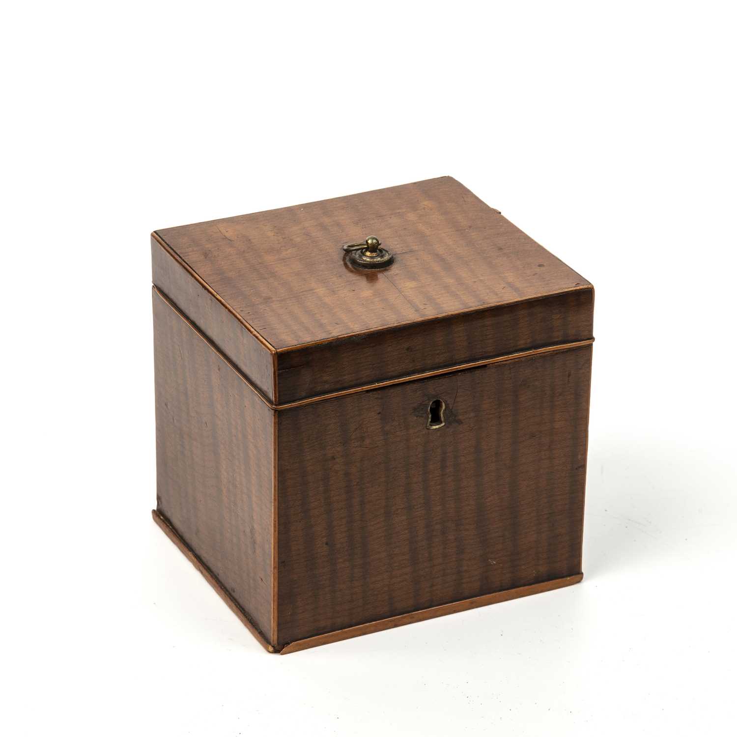 A George III possibly fustic tea caddy of cube form with fiddle back veneer, a ring handle and a