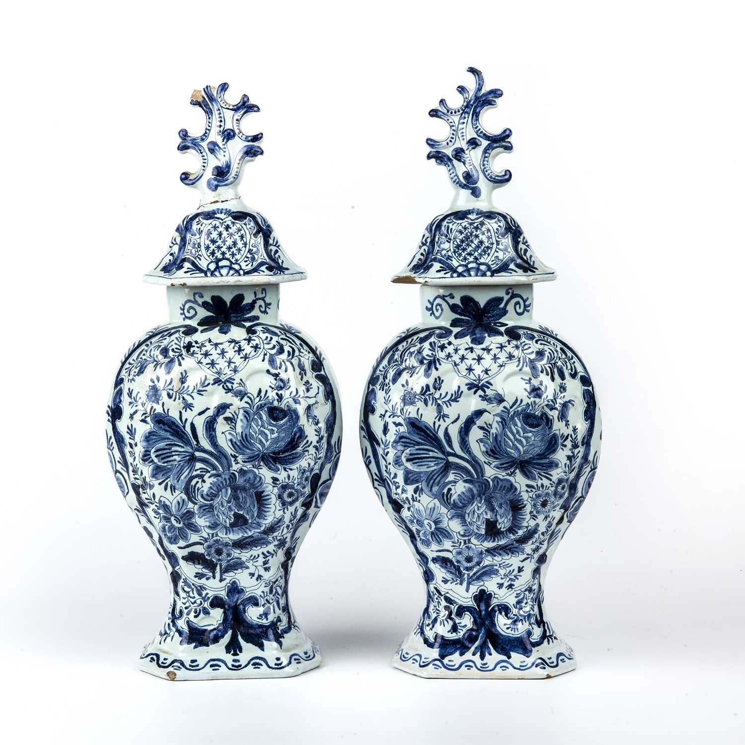 A pair of 19th century tin glazed vases and covers with blue and white foliate decoration, each 15cm