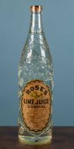 A large advertising 'Rose's Lime Juice Cordial' bottle