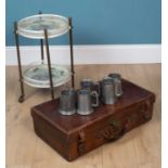 A suitcase, a drinks trolley, and pewter tankards