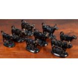 A herd of eight black glazed and parcel gilt North Country pottery cow creamers