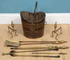 A set of brass fire irons together with two fire dogs and a brass bound bucket