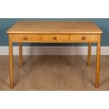 A pine veneered kitchen table with three fitted drawers with turned handles along the side 77cm high