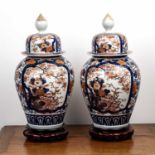 Pair of Japanese imari vases and covers late 19th /early 20th Century, on later wooden stands,