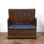 Elm panelled settle Late 18th/ early 19th Century, of small proportions, standing on bracket feet,