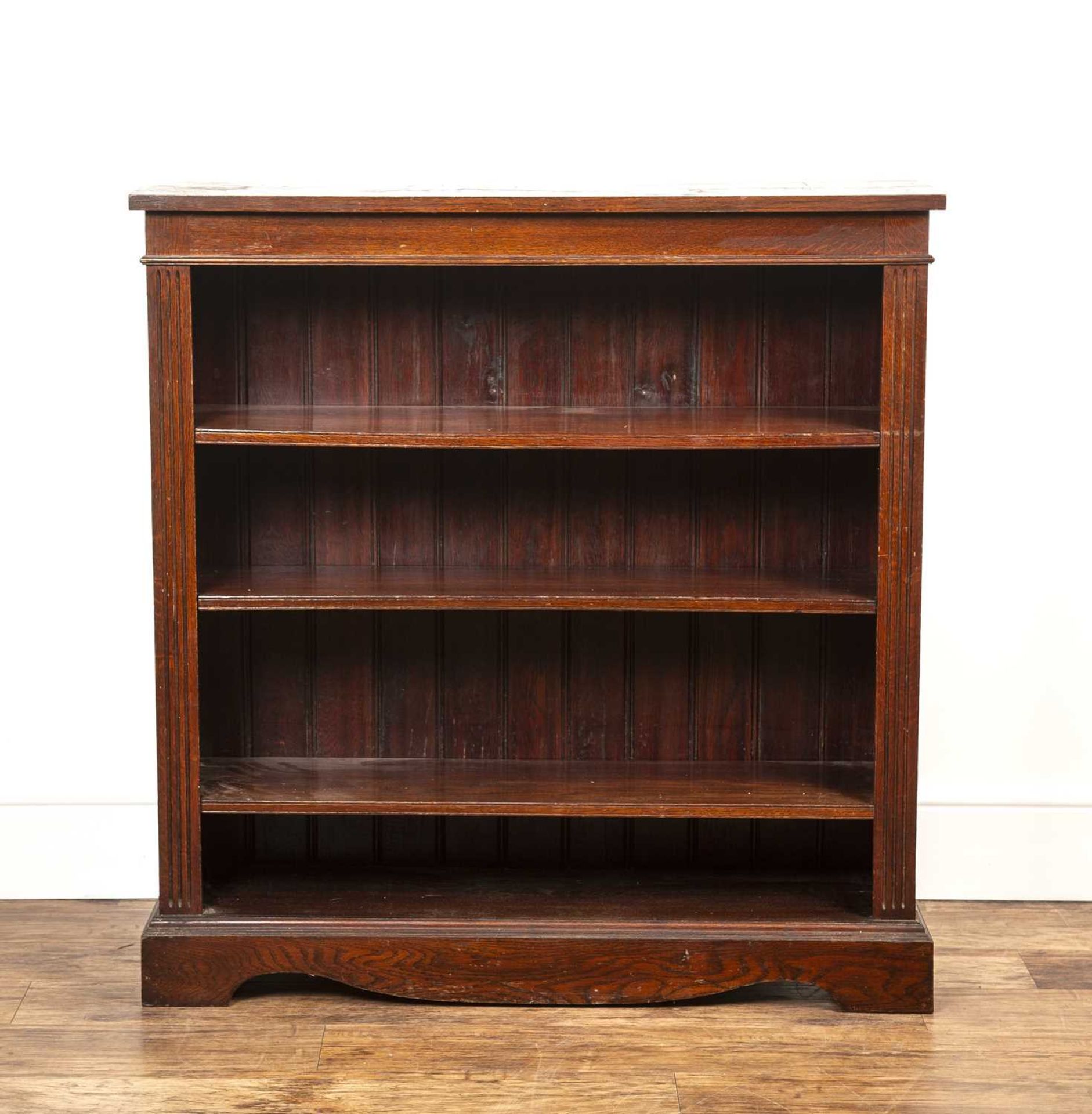 Oak open front bookcase with three height adjustable shelves flanked by reeded effect columns on