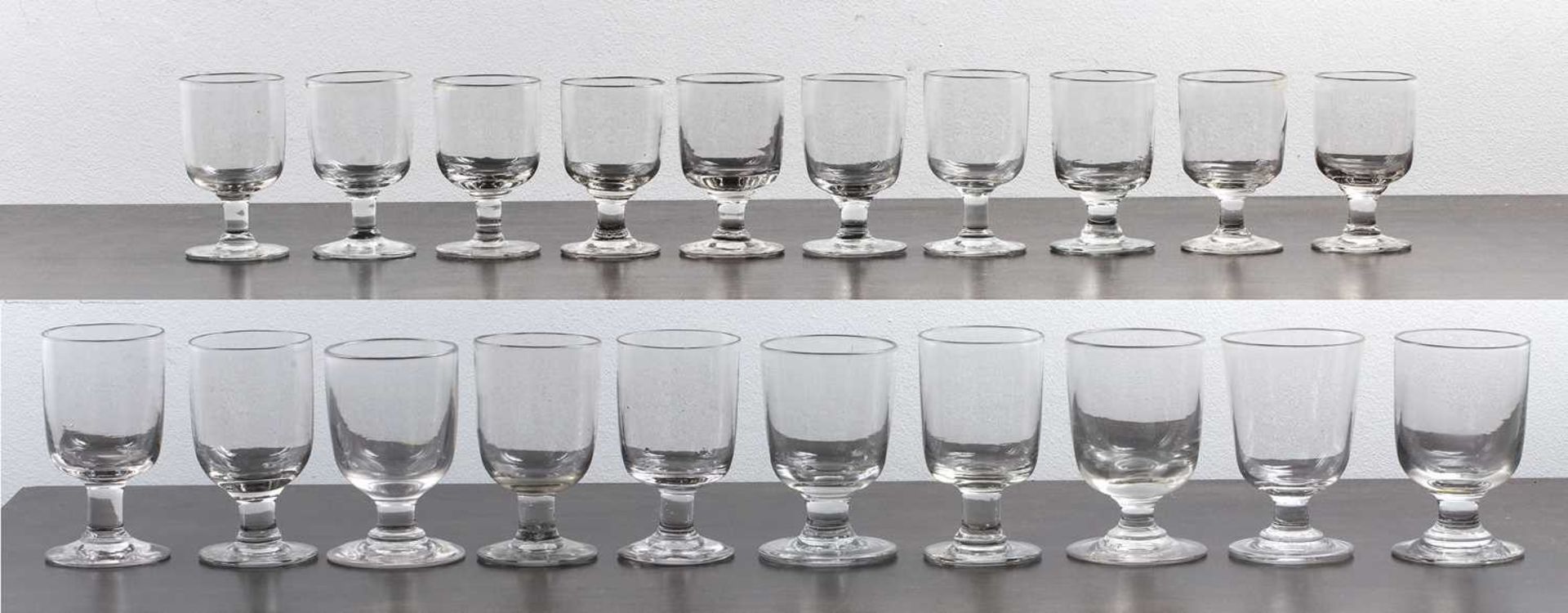 Collection of twenty handblown drinking glasses with bell shaped bowls, 19th Century, on plain squat