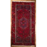 Blue and red ground rug Pakistan, with central stylised foliate panel and geometric border, 106cm