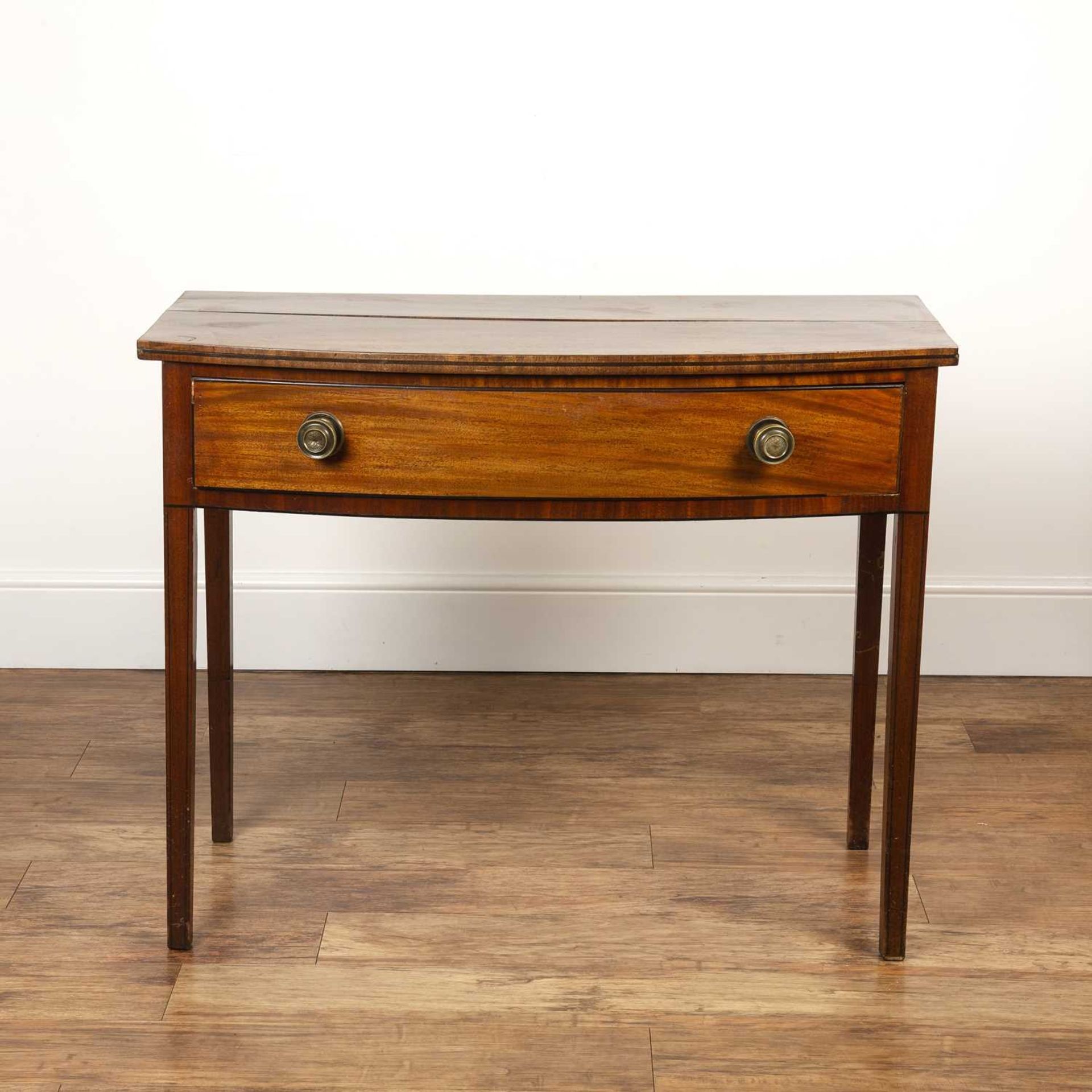 Mahogany bow fronted side table with single frieze drawer and brass handles, standing on square