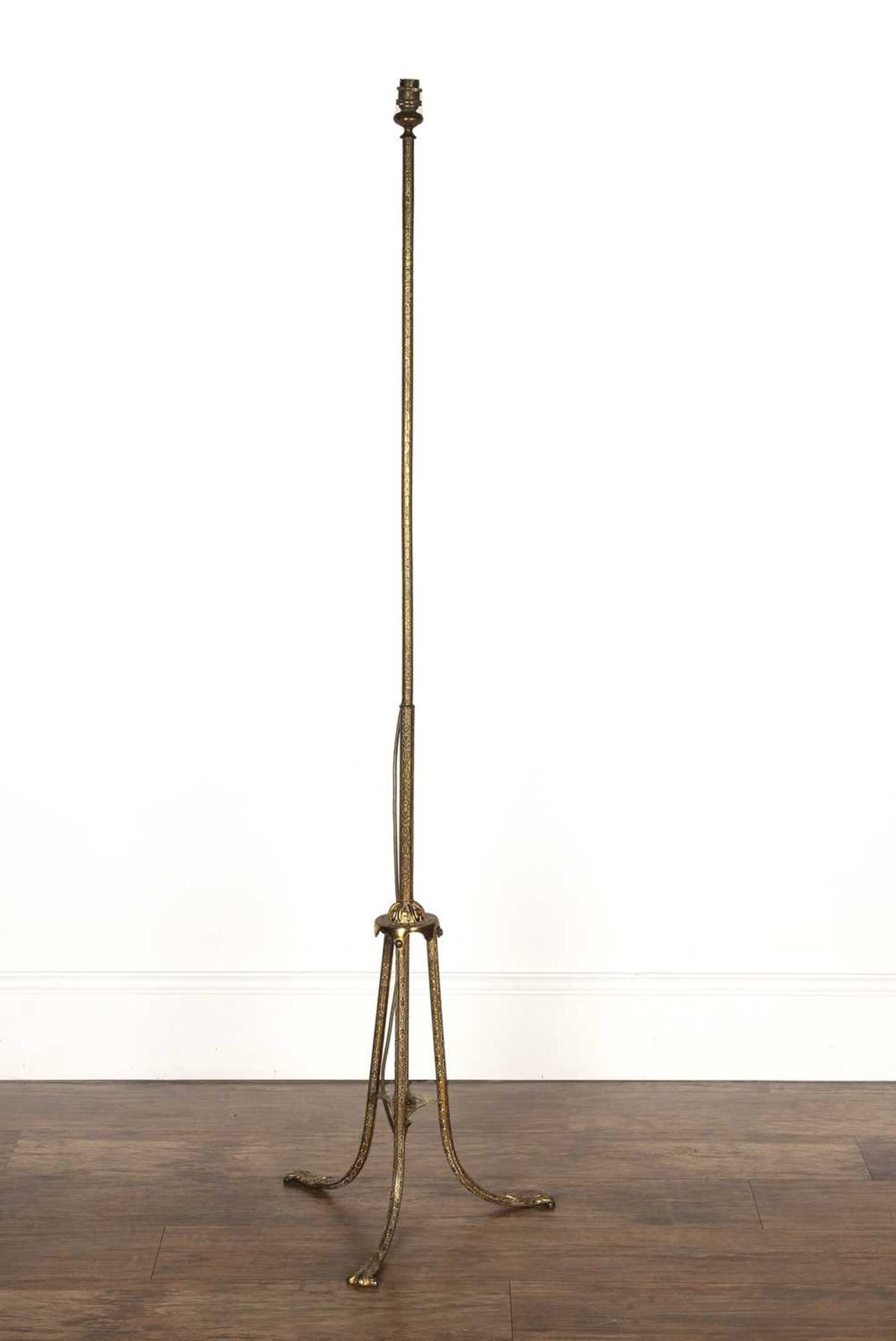 Brass standard lamp 20th Century, with repeating scrolling motifs, standing on a tripod base,