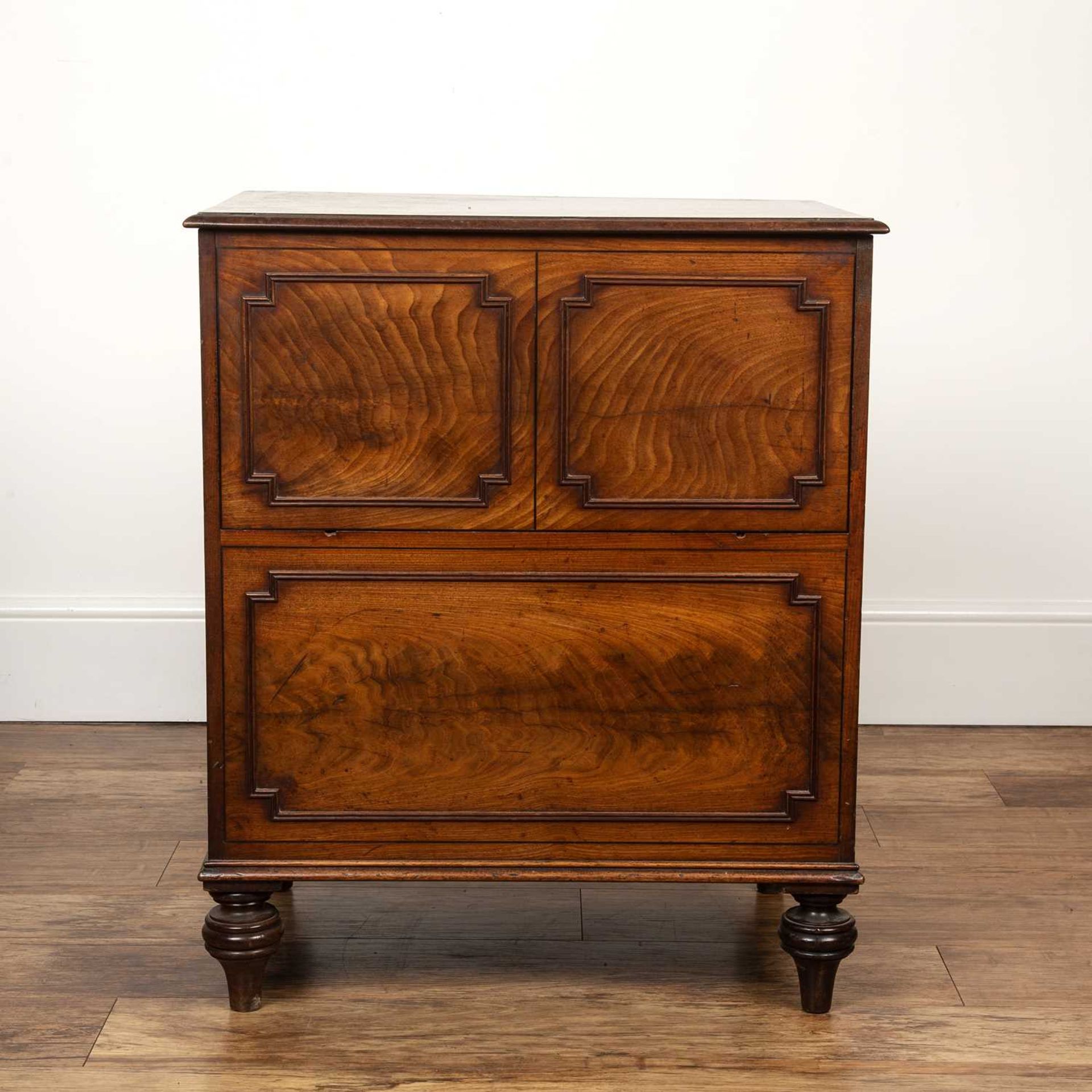 Mahogany commode with lift up top George III, the front with fielded panels, standing on turned