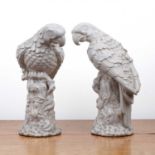 Pair of white glazed models of parrots Continental, each raised on a leaf encrusted base, 27.5cm