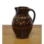 Winchcombe Pottery early studio pottery jug, decorated with slipware, impressed mark to the footrim,
