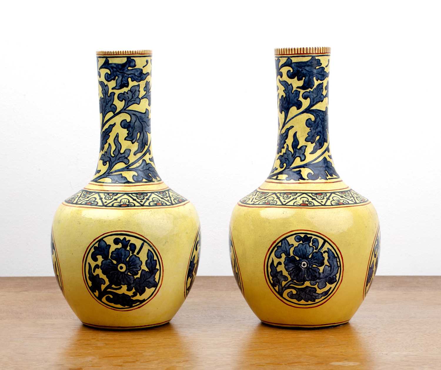 Pair of Mintons pottery vases with blue foliate designs on yellow ground, decorated in the Chinese