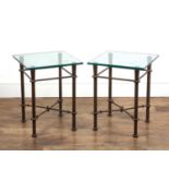 Pair of side or occasional tables standing on decorative metal bases with square glass tops, the