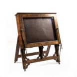 A Victorian walnut easel folio stand with hinged top and glazed fall with brass rod supports, the