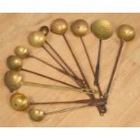 A collection of antique wrought iron and brass ladles and strainers