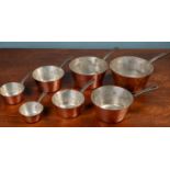 A set of seven graduated copper saucepans