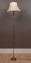 A tall thin modern brass floor standing lamp