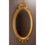 An antique gilt oval wall mirror