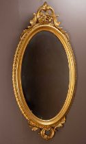 An antique gilt oval wall mirror