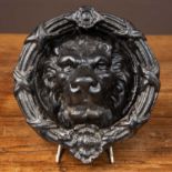 A cast iron door knocker with lion mask