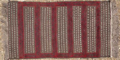 A striped maroon rug together with a further small rug