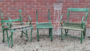A wirework plant stand and three green garden chairs