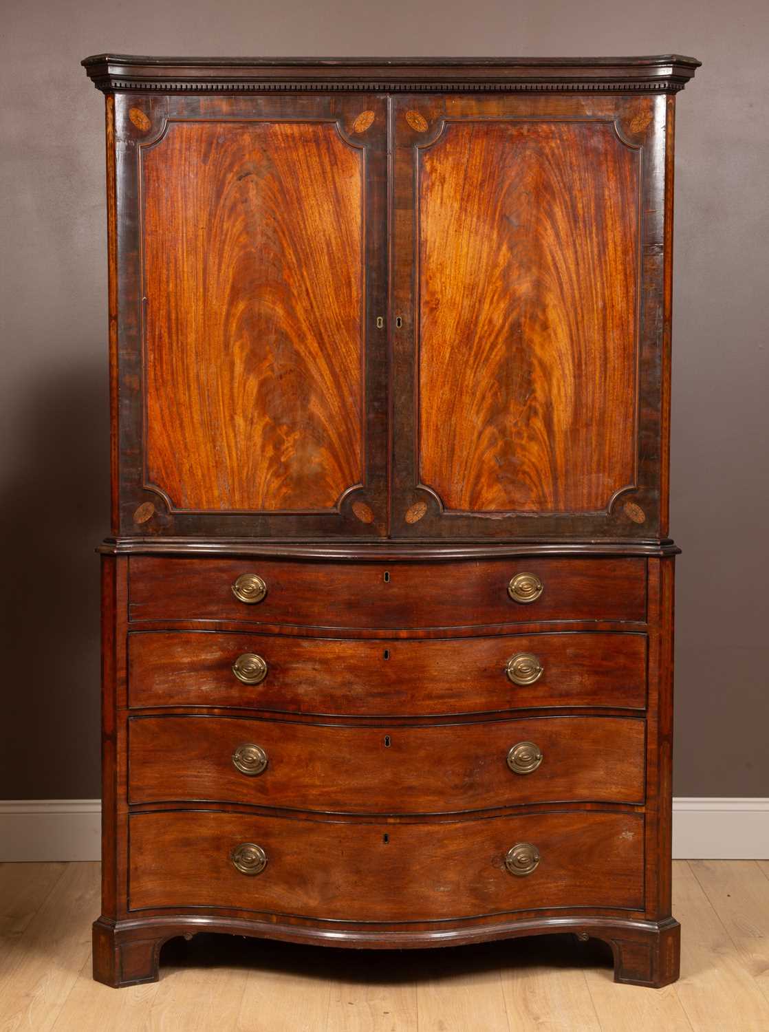 A George III mahogany serpentine fronted linen press