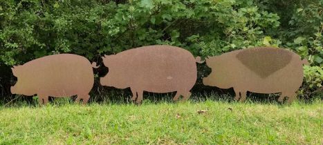 A group of three steel profile pig decorations