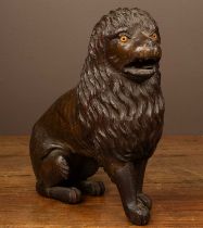 An antique carved hardwood sculpture of a lion