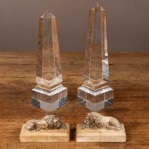 Two lucite obelisk ornaments and a pair of plaster lions